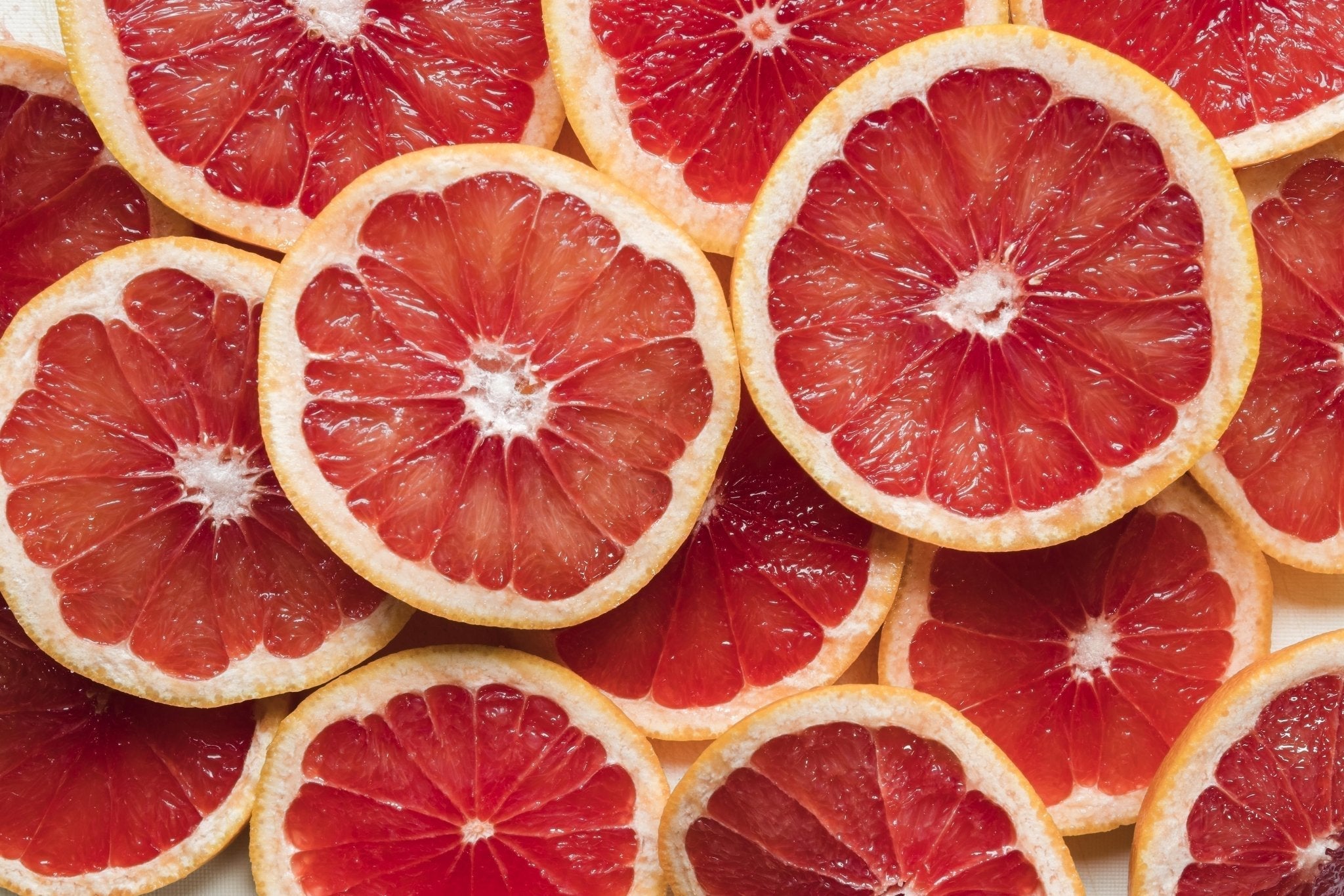 Close-up of fresh grapefruit slices with vibrant pink flesh and pale rind